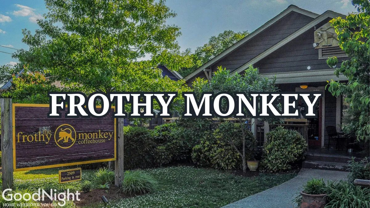 An exterior scene featuring warm signage, a welcoming entrance, and well-tended landscaping, inviting both locals and visitors. The setting suggests spaces for casual meetings, coffee breaks, or unwinding between work engagements.